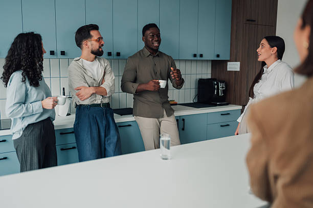 istock Diverse coworkers enjoying an informal coffee break in modern office kitchen 2251060977