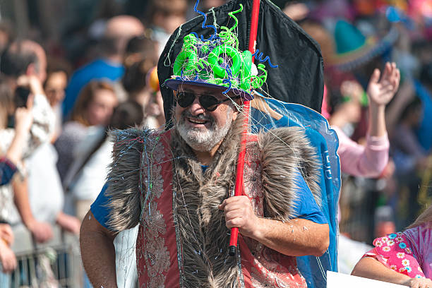 Limassol, Cyprus - March 26, 2023: Smiling bearded man wearing a colorful costume walking in the street during a carnival parade