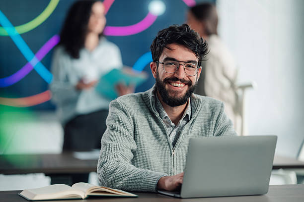 istock Smiling man working on laptop in modern office 2251064210