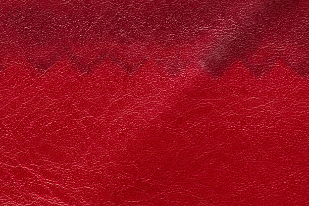 istock Horizontal full-frame macro of a leather surface transitioning from vibrant red to a darker burgundy shade, highlighting the grain 2251064335