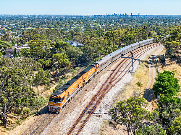 Panorama, Australia - December 31, 2020: Journey Beyond's Great Southern luxury passenger train begins the climb up through the scenic Adelaide Hills, leaving the city behind in the distance as it starts its 2885km (1792 mile) journey to Brisbane via South Australia, Victoria, New South Wales and Queensland. The train is led by two diesel-electric locomotives specially painted with the Great Southern  logo.