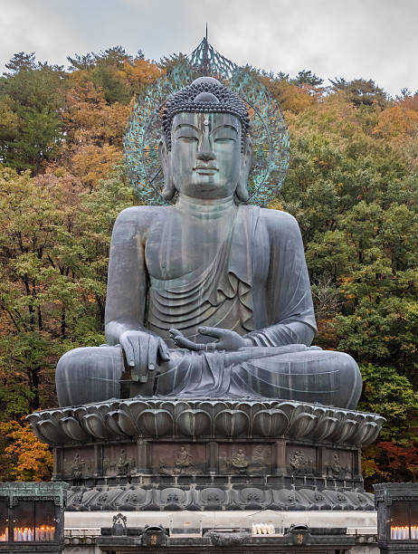 istock Bronze seated Buddha statue surrounded by fall autumn trees 2251075924