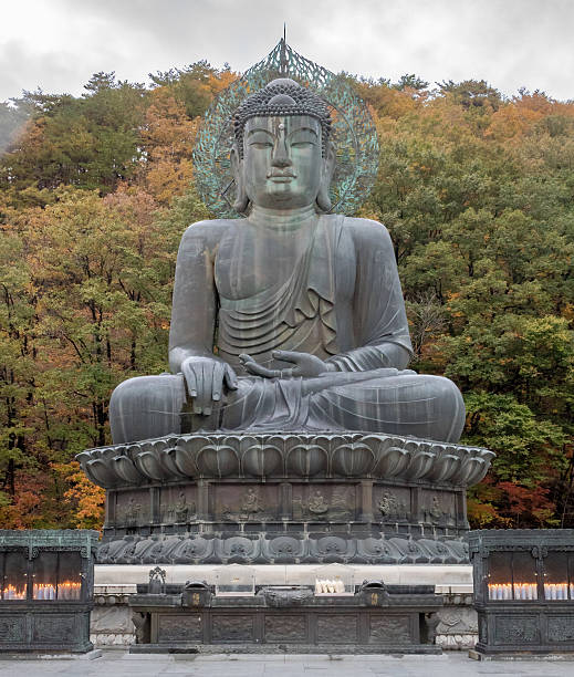 istock Bronze seated Buddha statue surrounded by fall autumn trees 2251075925