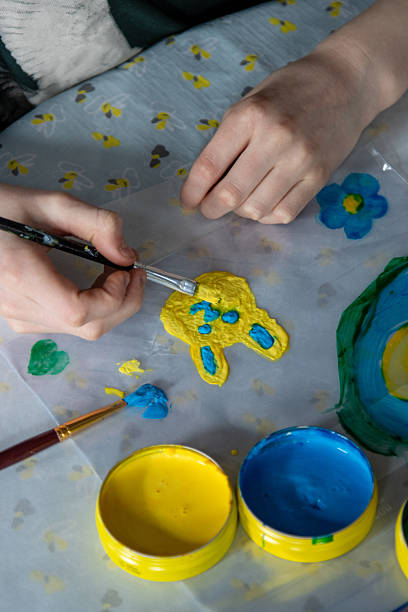 istock Child making homemade spring window clings with paint and brush 2251080186