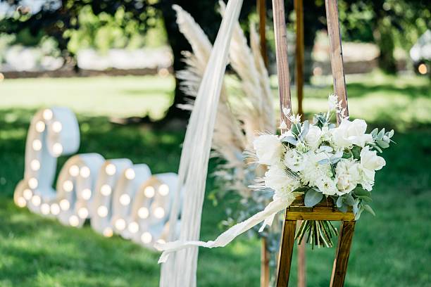 istock A wooden frame adorned with white flowers and pampas grass, creating a boho-chic backdrop. 2251080979
