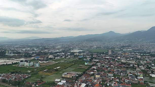 Landscape aerial view of Bandung City, West Java, Indonesia, with Mount Manglayang as a scenic background.
