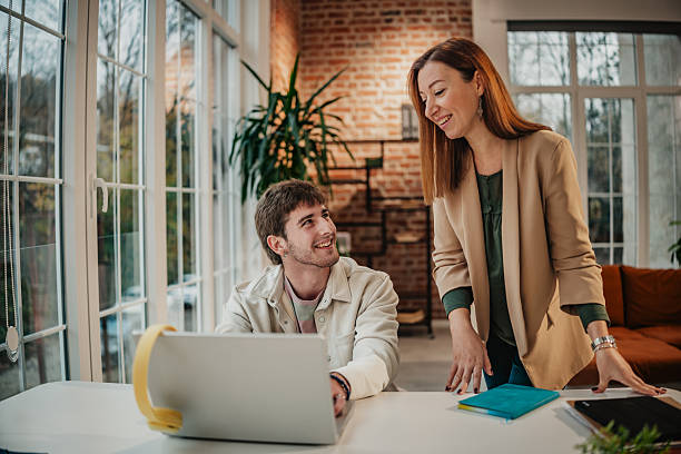 istock Young adults collaborate in a modern office space with laptops and plants during a work session in daylight 2251084548