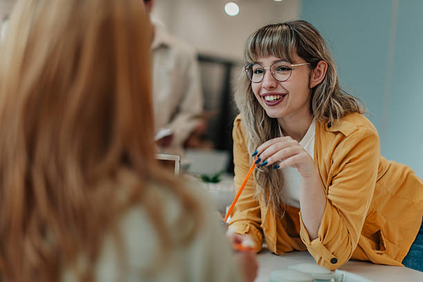 istock Young adults working in modern office space engaging in conversation and collaboration during the day 2251087166