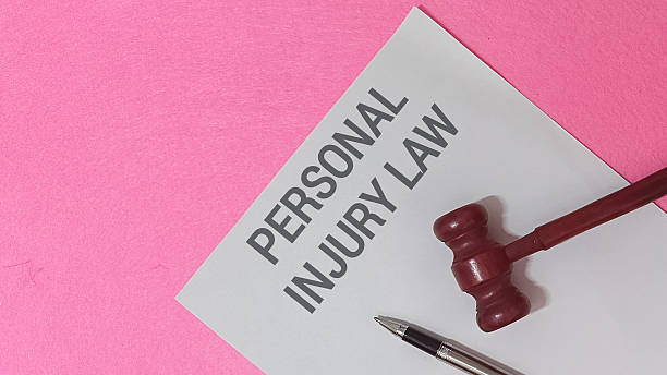 Personal injury law concept is clearly presented with a document featuring bold text resting diagonally next to a miniature wooden gavel.