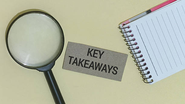 istock Magnifying glass and spiral notebook sit near a small cardboard tag reading key takeaways symbolizing the critical process of detailed examination. 2251093523