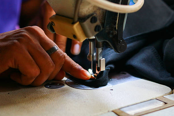 istock A sewing machine and the hand of a tailor working on a sewing machine 2251094924