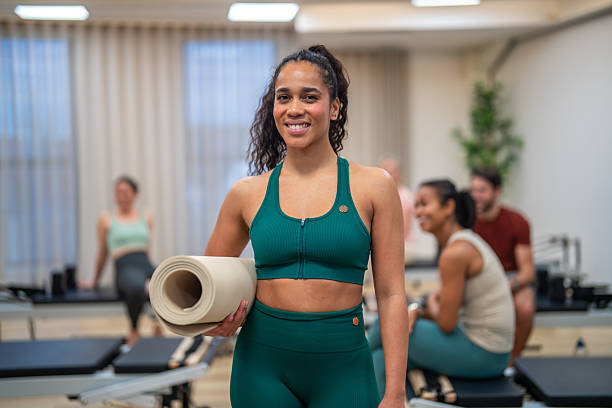 istock Smiling Hispanic Woman Holding Exercise Mat in Pilates Studio 2251101032