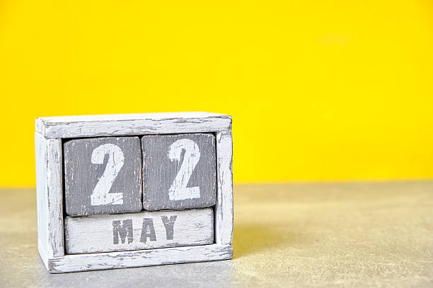 istock May 22 calendar made wooden cubes yellow background.With an empty space for your text. 2251110393