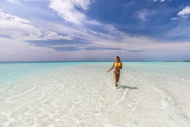 istock Young happy woman having fun while running through sea. 2251111425