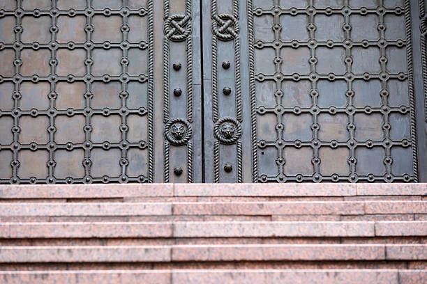 Decorative metal doors stand proudly above smooth granite steps in soft light. Kyiv, Ukraine. December 8, 2025.