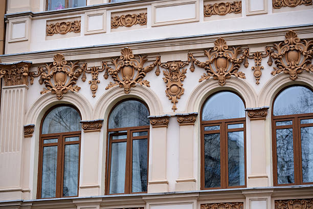 Intricate decorations frame beautiful windows on a historical building's façade.
