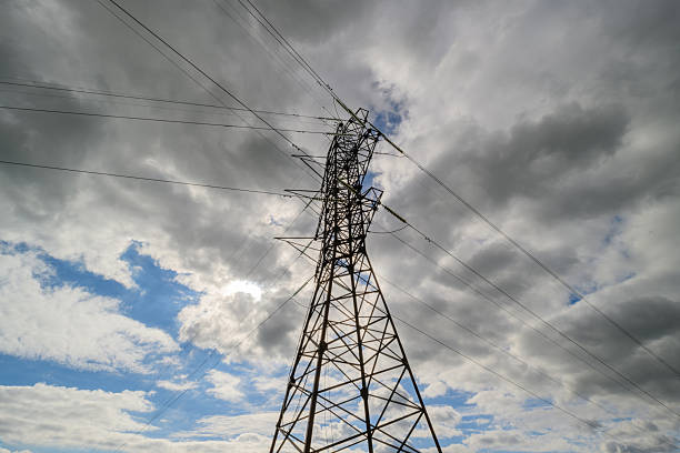 A striking electricity tower silhouetted against a cloudy sky, epitomizing energy and infrastructure.