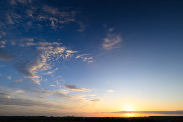 A stunning sunset with vibrant colors across a tranquil horizon, soft clouds creating a serene atmosphere