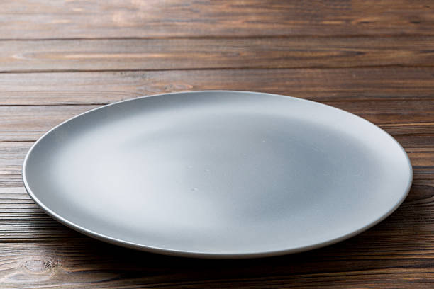 Perspective view of empty grey plate on cement background. Empty space for your design.