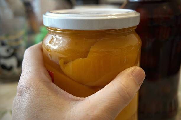 istock Peach compote and sour cherry compote in jars on the table, close-up 2251118497