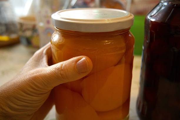 istock Peach compote and sour cherry compote in jars on the table, close-up 2251118502