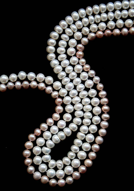 istock White and pink pearls on the black silk 2251122125