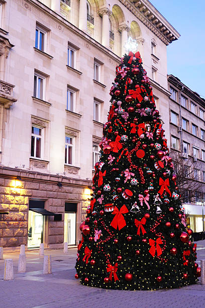 Night shot of an illuminated artificial Christmas tree on a city square in blue hours.