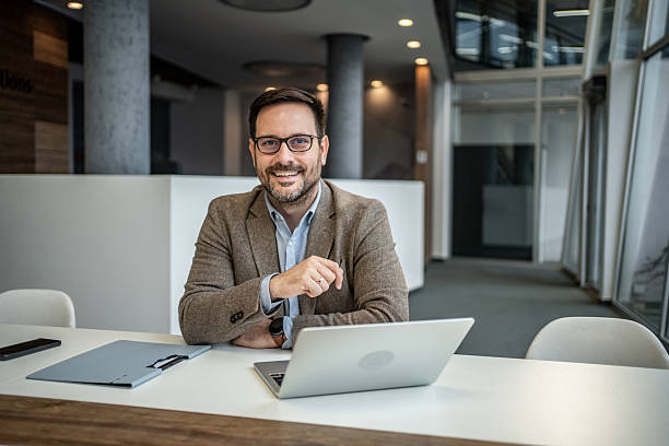 istock Confident businessman sitting at office desk looking at camera 2251127295