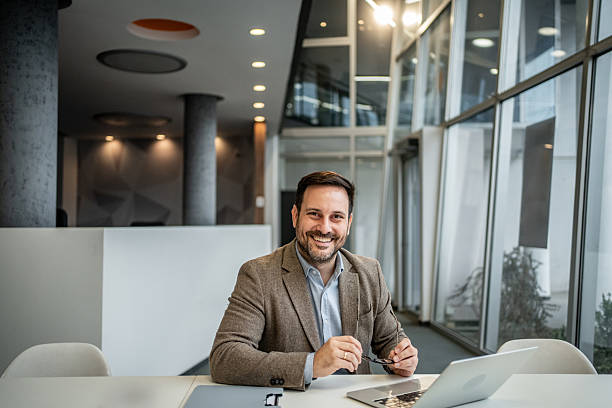 istock Confident businessman smiling at modern office desk 2251127309
