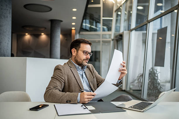 istock Businessman reviewing financial documents in modern office 2251127319
