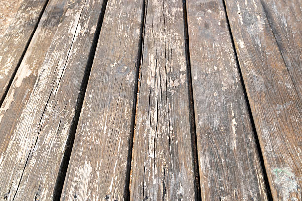 Closeup of rustic wooden planks of a picnic table in a park, showing natural grain, weathered texture and peeling paint, perfect for backgrounds, copy space and product mockups