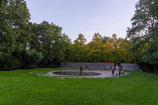 Berlin, Germany - October 03, 2025: Sunset scene of the Memorial to the Sinti and Roma of Europe murdered under National Socialism, with locals and visitors, in Berlin, Germany