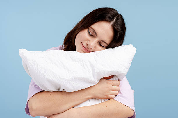 istock Young woman closing eyes, hugging a soft pillow, feeling comfortable and relaxed 2251132526