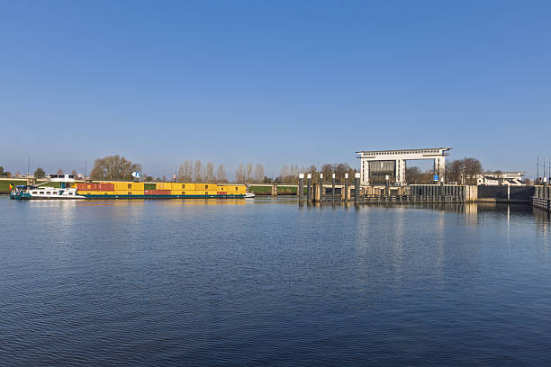 Inland cargo ship with containers approaching the Princess Beatrix Lock in Nieuwegein. Freight water transport on the Lekkanaal, Netherlands. Nieuwegein Netherlands, 21 November 2025.
