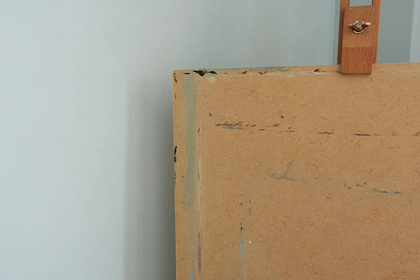 istock wooden easel with blank canvas on white wall, close up 2251140361