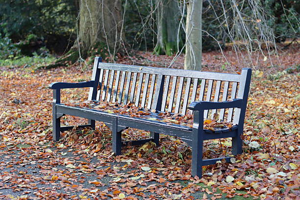 London, England, April 30 2023: Two ladies sitting on a bench in Kensington Gardens enjoying a summer day