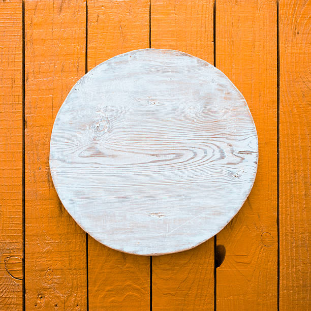 istock wooden plate, orange background 2251145916