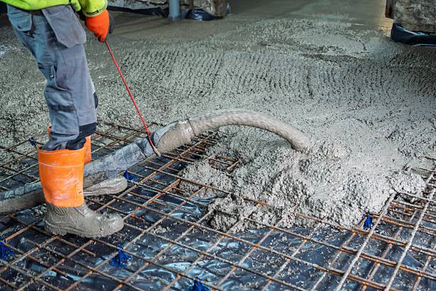 istock Concrete Pouring on Construction Site with Worker Leveling and Reinforcement Grid 2251148159