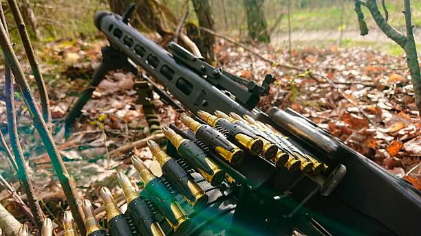 istock Heavy Machine Gun with Ammunition Belt on Forest Floor Powerful Firepower and Tactical Gear 2251150463