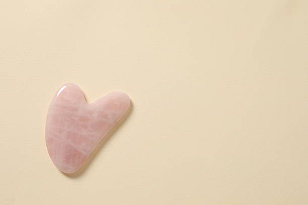 istock Gouache scraping from rose quartz on a pastel background. Natural stone massager, lymphatic drainage massage beauty tools, Chinese therapy. 2251151202