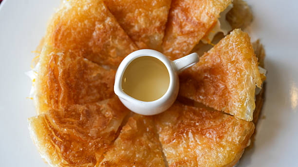 Delicious Plate of Crispy Fried Dough with Sweet Sauce Centered on White Table