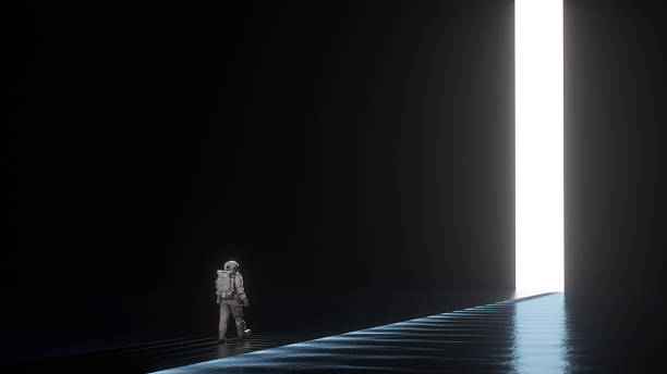 istock Astronaut walking toward glowing doorway in dark space 2251151627