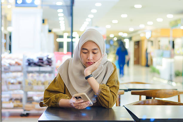 istock Bored or Tired Muslim Woman Waiting While Using Phone in Mall 2251153120