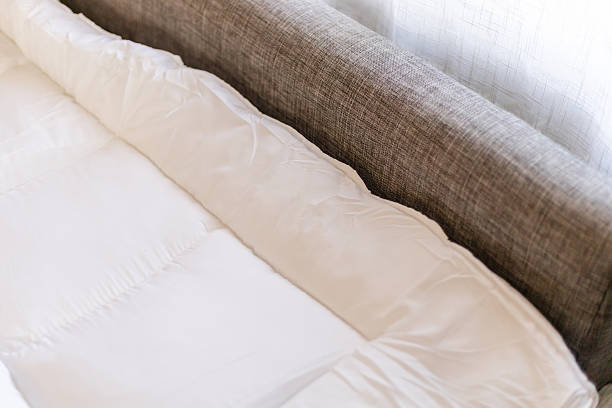istock A mattress topper is laid on a sofa, providing a comfortable sleeping surface. This setup is used for resting on the couch at night. Soft fabric is seen next to the textured sofa 2251153867