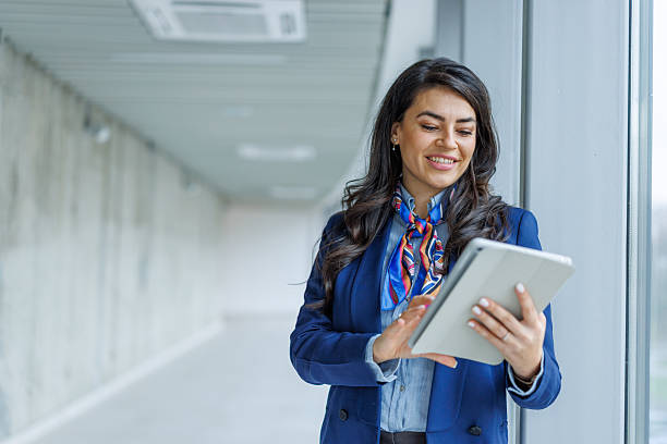 istock Businesswoman standing in office hallway using digital tablet 2251157353