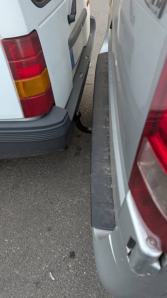 istock Urban Parking Lot Shows Closely Parked Vans With Visible Exhaust And Possible Scratch Risks 2251157496