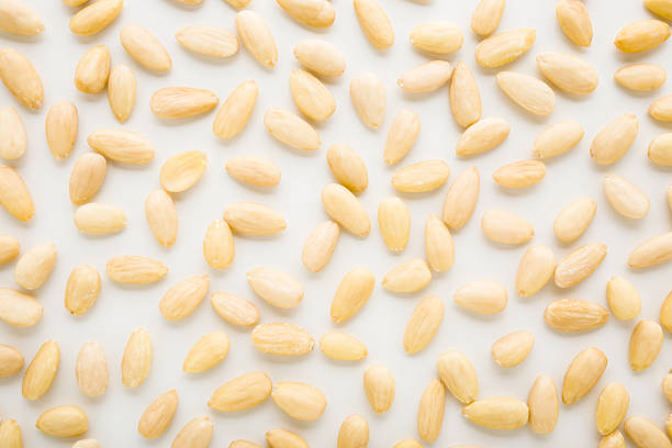 istock Almond nuts on light gray table background. Closeup. Food pattern. Top down view. 2251158824