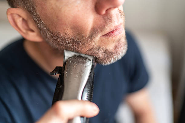 istock Man trimming beard using electric shaver for personal grooming 2251163504