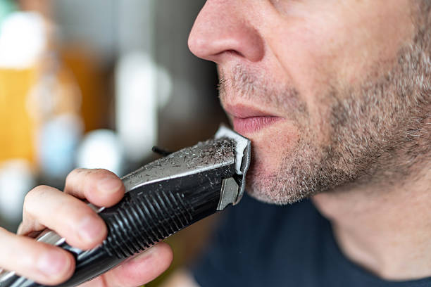istock Man shaving beard with electric trimmer, grooming routine 2251163649