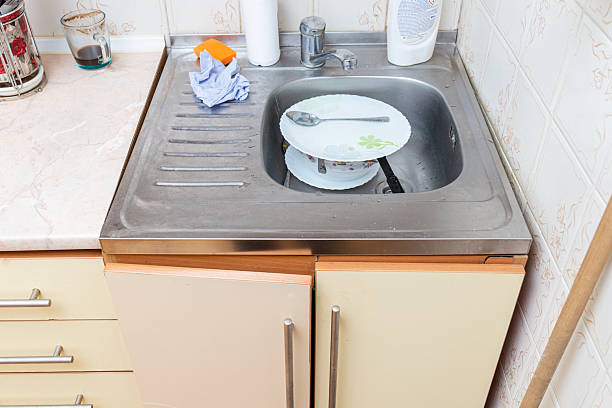 istock An old, cracked kitchen sink with unwashed dishes. 2251165655